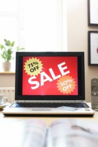 Tablet with "sale, 75% off, 50% off" on the screen