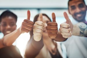 Four people giving a thumbs up