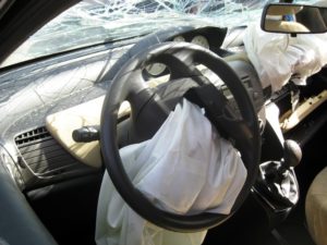 Inside of a car with the airbags deployed and a cracked windshield