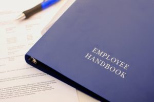 Binder titled "employee handbook"