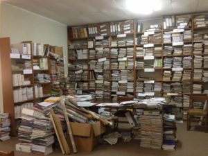 Shelves and a table overflowing with records and papers
