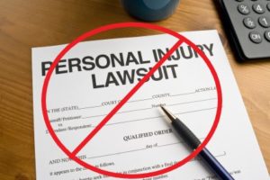 Paper titled "Personal Injury Lawsuit" with a crossed out circle over it