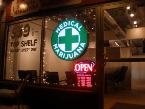 Front window of Medical Marijuana dispensary with an open sign