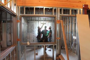 Construction workers inside of a building with the framework showing