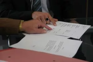 Two people pointing at a piece of paper on a table