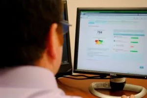 Person looking at a desktop computer looking at credit report